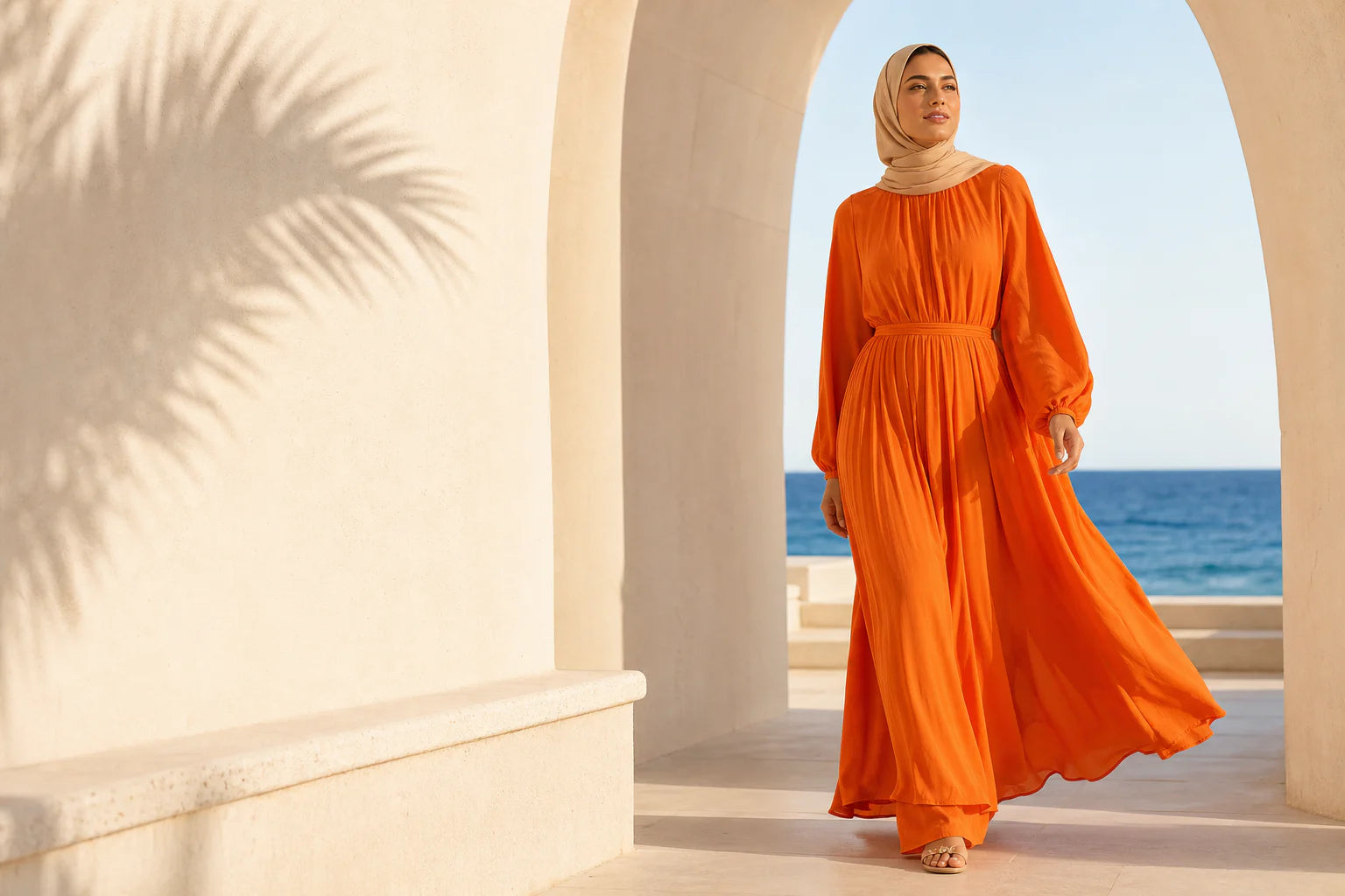 Woman wearing an orange Buskins dress in a sunlit setting
